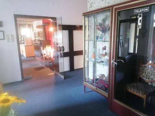 a room with a glass door and a room with a chair at Hotel Schachten in Lindberg