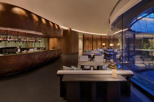 a restaurant with tables and chairs and a bar at Shu Hua Hotel Tianmu Mountain, Curio Collection By Hilton in Hangzhou