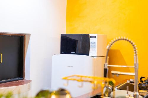 a microwave sitting on top of a refrigerator in a kitchen at Villaroma Furnished Penthouse Suites in Eldoret