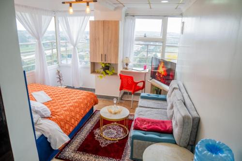 a living room with a couch and a bed at Villaroma Furnished Penthouse Suites in Eldoret