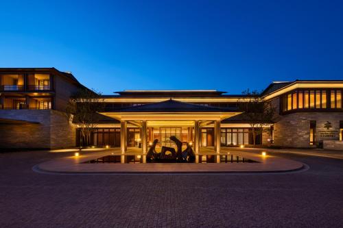 a building with a fountain in front of it at night at Shu Hua Hotel Tianmu Mountain, Curio Collection By Hilton in Hangzhou