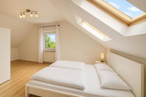 a white bedroom with a bed and a window at Cozy City Apartments 3, 2-Room Flat for Vacation & Messe Düsseldorf, Perfect Connectivity in Ratingen