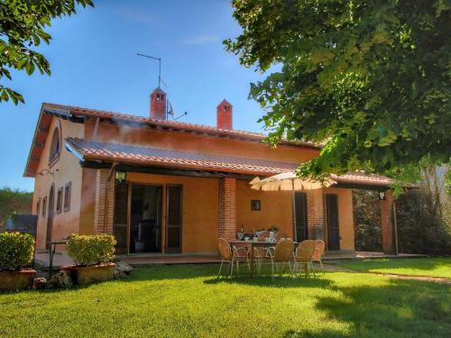 a house with a table and chairs in the yard at Belvilla by OYO Tosco in Valiano