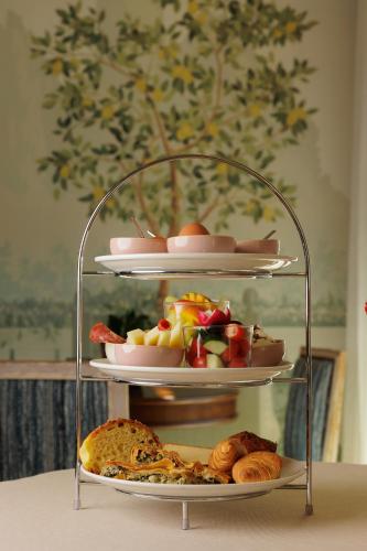 a three tiered shelf with different types of bread and pastries at Albergo Botti in Corfu Town