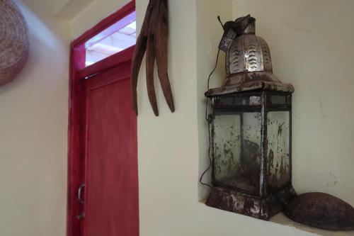 an old lantern on a wall next to a red door at Gite Megdaz in Megdaz