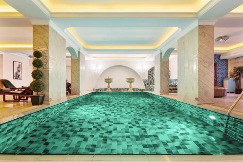 a swimming pool in a hotel with a green tile floor at Hotel Ickale in Ankara
