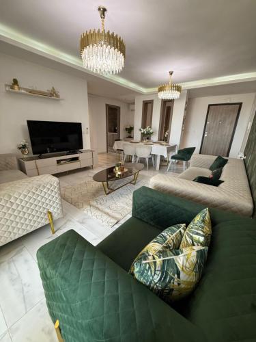 a living room with a green couch and a television at Élégant appartement avec parking privé proche aéroport et centre ville Tunis Laouina in El Aouina