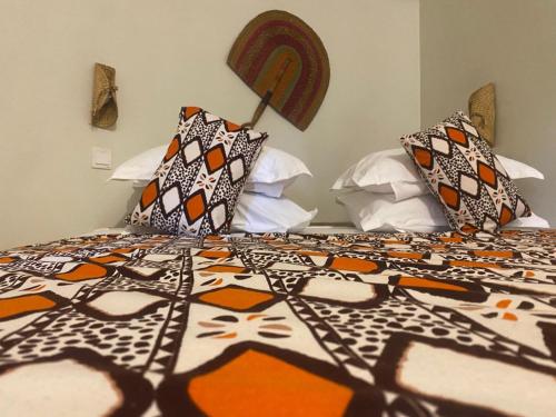 a bed with a patterned comforter and pillows on it at Oasis beach resort in Cape Coast