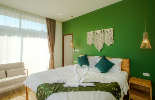 a green bedroom with a bed with a white swan on it at Paradise House - 1BR - Calm & Green Garden Stay - Heart of Thong Sala - 4K SmartTV in Koh Phangan