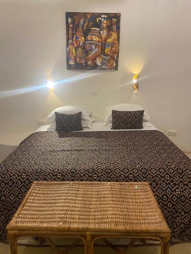 a bedroom with a bed and a painting on the wall at Oasis beach resort in Cape Coast