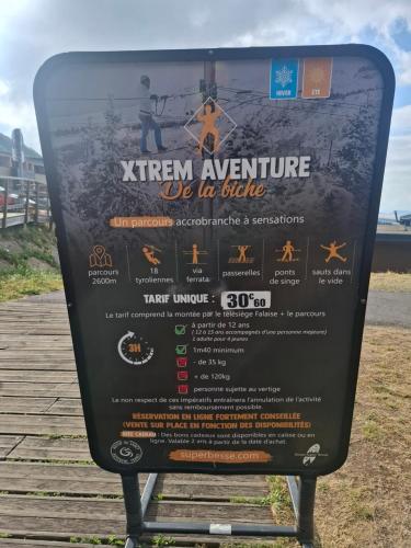 a sign on a boardwalk with a picture of a sign at Chalet Emma appartement tout équipé et refait a neuf dans une résidence 3 étoiles in Besse-et-Saint-Anastaise