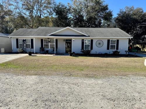 Una casa blanca con un reloj en la parte delantera. en Hank and Margie's Place, 