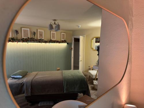 a bedroom with a bed and a mirror at Holdsworth House Hotel in Halifax