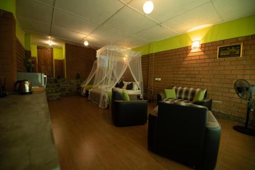 a room with couches and a bed and a brick wall at Ayubo Ella - Bed & Breakfast in Ella