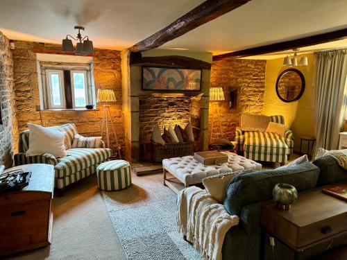 a living room with couches and a stone wall at Holdsworth House Hotel in Halifax