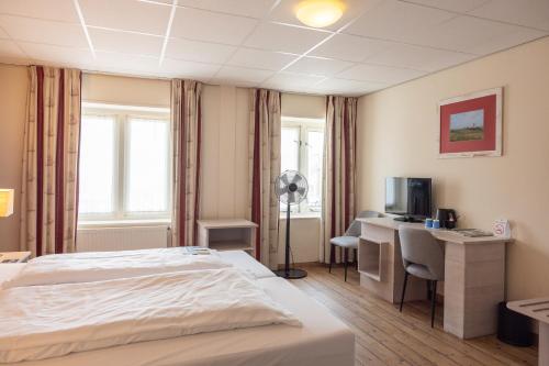 a hotel room with a bed and a desk at Fletcher Hotel - Restaurant de Cooghen in De Koog