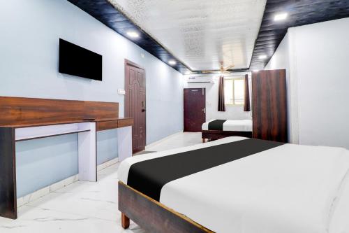a bedroom with a bed and a flat screen tv at Hotel O Dharohar in Rishīkesh
