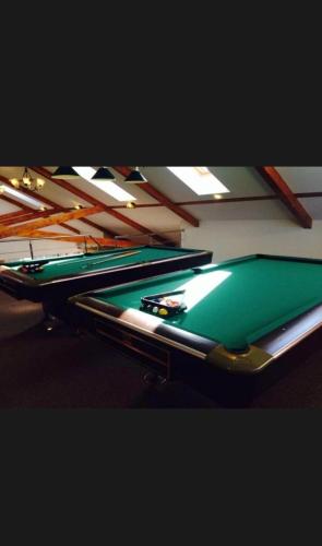 a row of green pool tables in a room at Hotel Bran Dracula in Bran