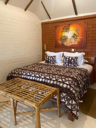 a bedroom with a large bed and a bench at Oasis beach resort in Cape Coast