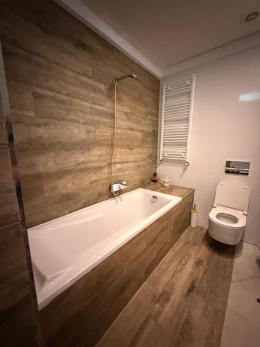 a bathroom with a white tub and a toilet at Élégant appartement avec parking privé proche aéroport et centre ville Tunis Laouina in El Aouina