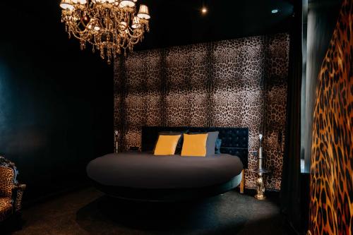 a bedroom with a bed with a chandelier at Designer Hôtel in Heusy
