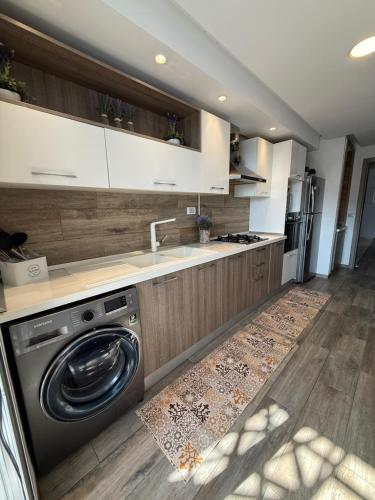 a kitchen with a washing machine and a sink at Élégant appartement avec parking privé proche aéroport et centre ville Tunis Laouina in El Aouina