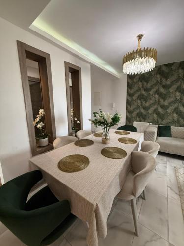 a dining room with a table and chairs at Élégant appartement avec parking privé proche aéroport et centre ville Tunis Laouina in El Aouina