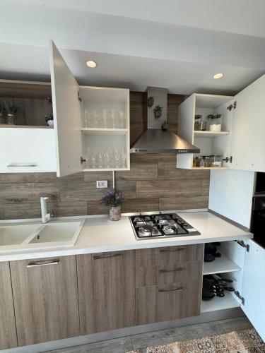 a kitchen with white cabinets and a stove at Élégant appartement avec parking privé proche aéroport et centre ville Tunis Laouina in El Aouina