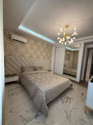 a bedroom with a bed and a large mirror at Élégant appartement avec parking privé proche aéroport et centre ville Tunis Laouina in El Aouina