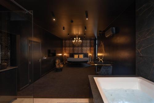 a bathroom with a bath tub and a bed at Designer Hôtel in Heusy