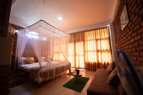 a bedroom with a canopy bed and a couch at Ayubo Ella - Bed & Breakfast in Ella
