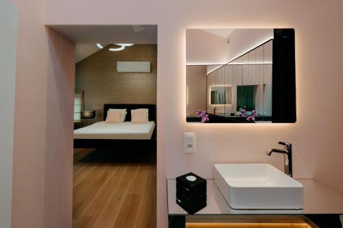 a bathroom with a sink and a bed and a mirror at Designer Hôtel in Heusy