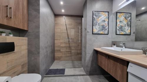 a bathroom with a sink and a shower at Q Apart Orion - dwupokojowy, klimatyzowany apartament przy Manufakturze z darażem Gratis, FV in Łódź
