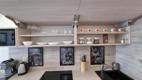 a kitchen with a counter with chalkboards on the wall at Q Apart Orion - dwupokojowy, klimatyzowany apartament przy Manufakturze z darażem Gratis, FV in Łódź
