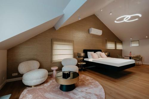 a bedroom with a bed and two chairs at Designer Hôtel in Heusy