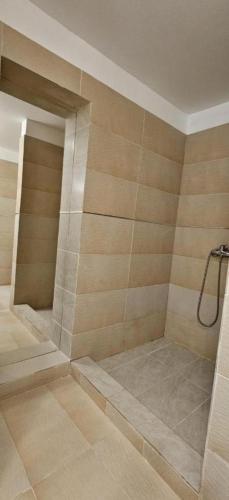 a bathroom with a shower with a tile wall at Hotel Bran Dracula in Bran
