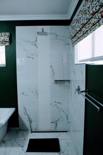 a bathroom with a white marble shower with a tub at Anyskop Guest Farm in Langebaanweg