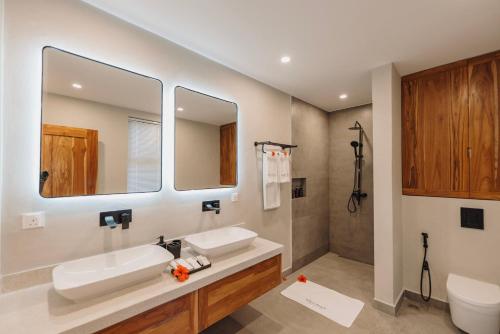 a bathroom with a sink and a toilet and a mirror at Johari Beach Resort, Kizimkazi Zanzibar in Zanzibar City