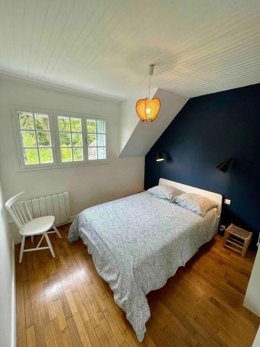a bedroom with a bed and a blue wall at Maison face à la mer in Sarzeau
