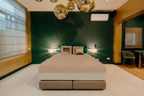a bedroom with a large bed with a green wall at Designer Hôtel in Heusy