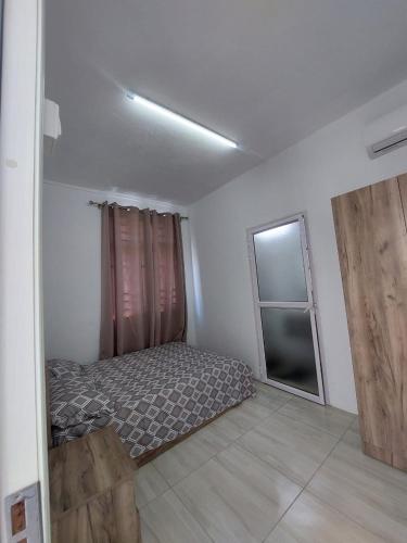 a bedroom with a bed and a window in it at Rose villa in Pereybere