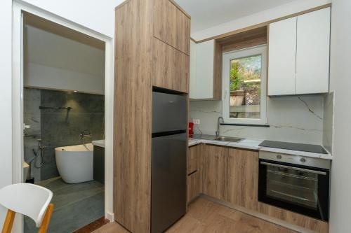 a kitchen with a refrigerator and a sink and a tub at Villa 3E Boge in Bogë