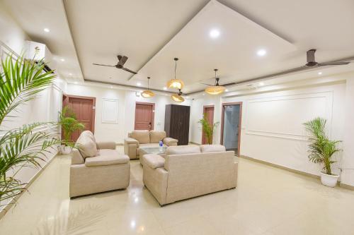 a living room with couches and a table and plants at White Pepper in Faridabad