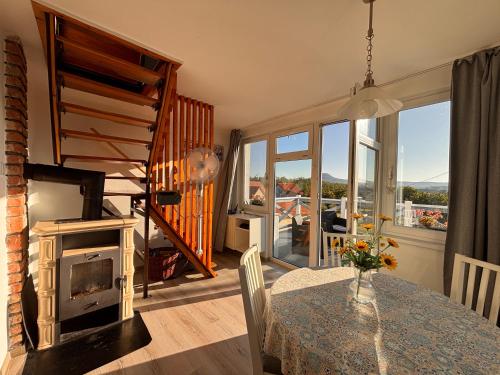 a living room with a table and a fireplace at Dandelion Vendégházak in Kisapáti