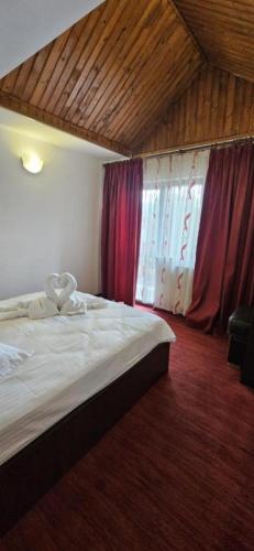 a bedroom with a large bed and a window at Hotel Bran Dracula in Bran