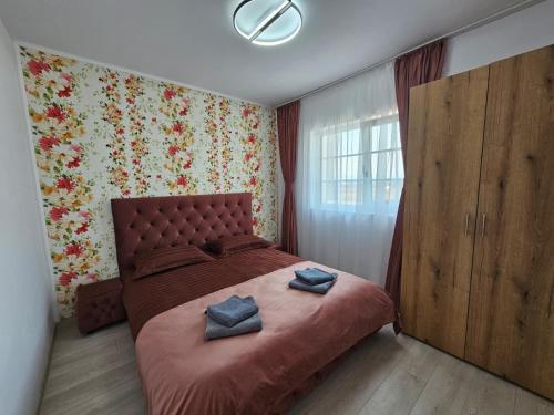 a bedroom with a large bed with two pillows on it at Green Hill Villa in Corneşti