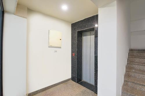 a hallway with a door and stairs in a building at White Pepper in Faridabad