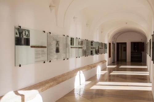 a hallway in a building with photographs on the wall at Sopron Monastery Hotel in Sopron