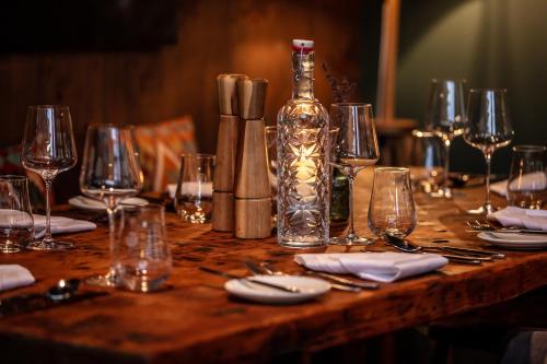 a wooden table with glasses and a bottle on it at Landgasthof Sagenhaft in Klagenfurt