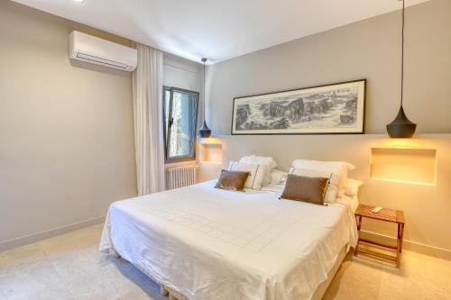 a bedroom with a large white bed with two pillows at House with private pool in Calella de Palafrugell